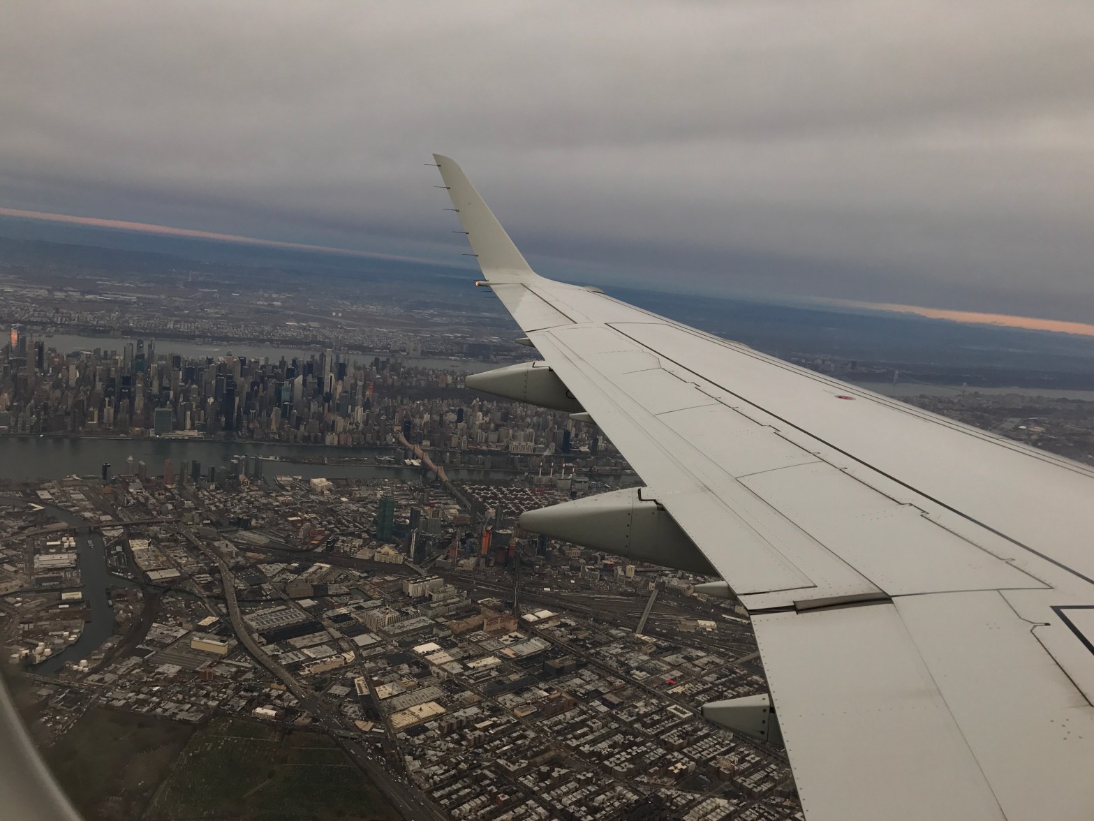 a picture of the wing of a plan with the ground showing below