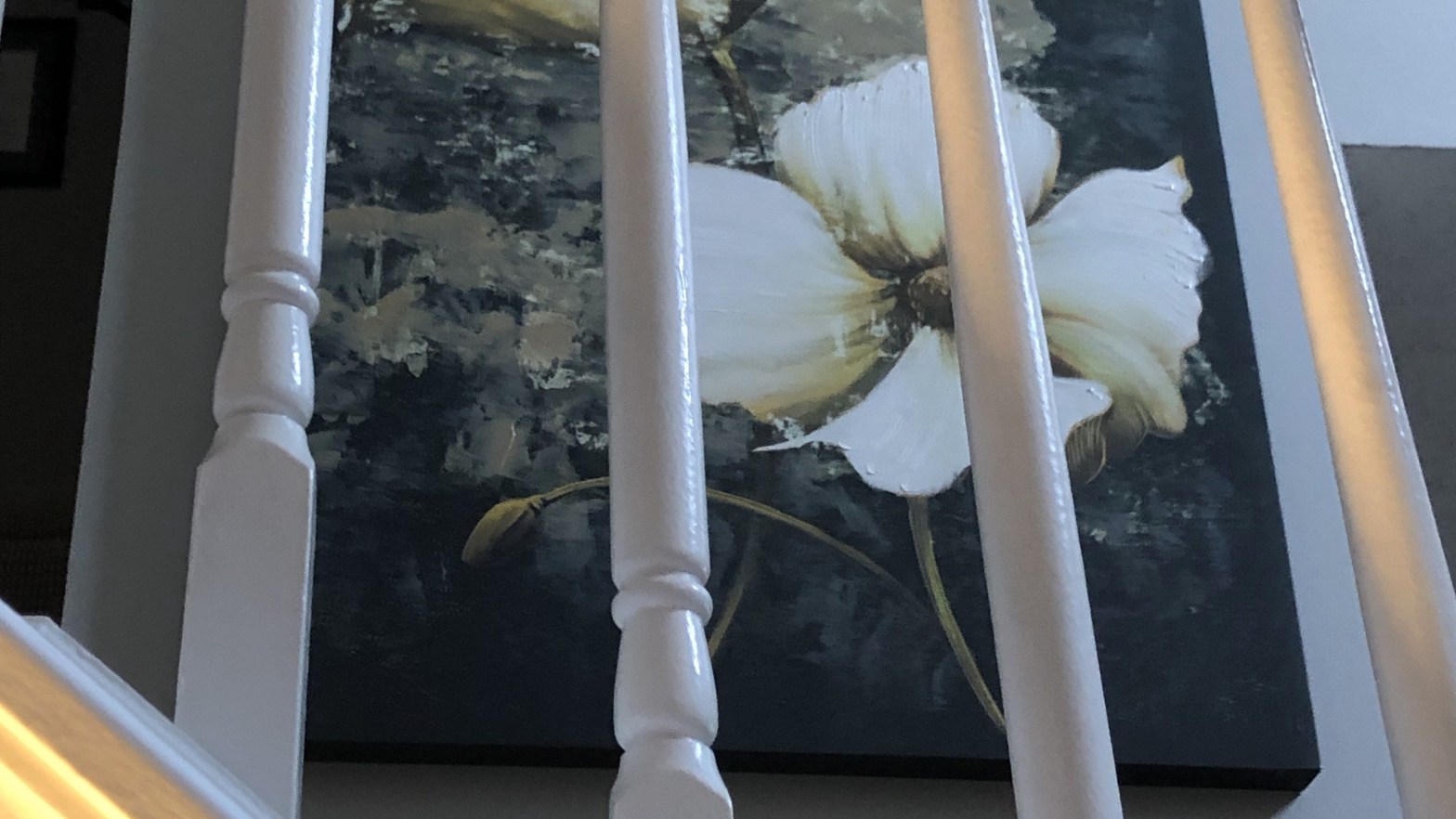 a picture of flowers behind a stair rail in a home